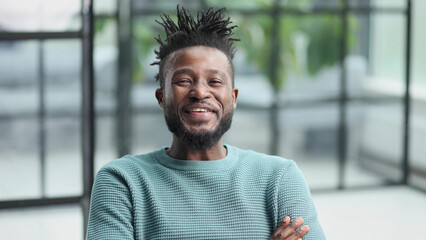 African American man in green sweater looking at camera
