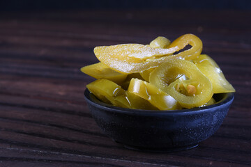 delicious mexican jalapeno peppers inside the canister isolated on black background.
