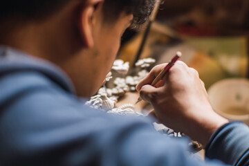 Hands painting clay in a clay workshop to teach people how to mold the material to create figures