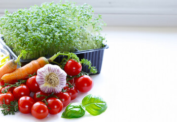 Cherry tomatoes and fresh lettuce and basil on a white background