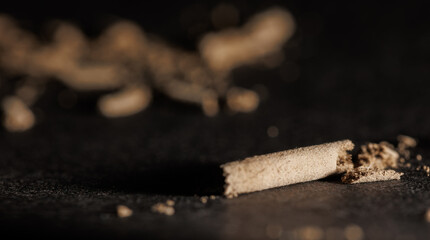 A closeup of ashes on a black textured background with bokeh effect for graphic and web design use