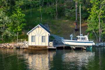 Stockholm Sweden Archipelago. Fishing hut, boat on platform over sea, reflection on water, nature.
