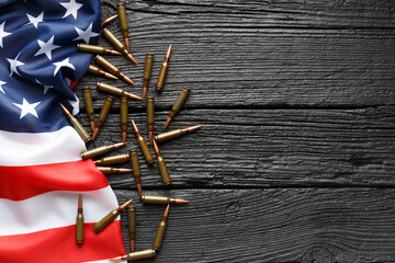 American flag, bullets, cartridges, ammunition on a black wooden background, top view, copy space