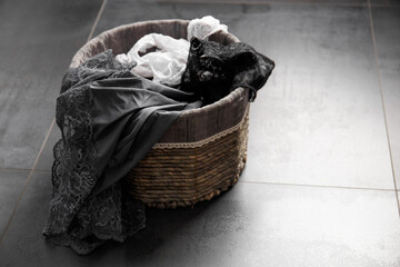 Women's underwear in a basket on a dark background.