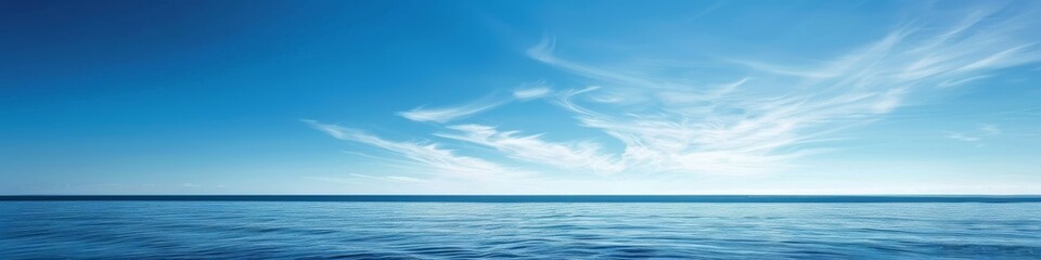 Fototapeta premium A clear blue sky over a calm sea, offering a vast expanse of water and sky for a tranquil summer backdrop with ample copy space