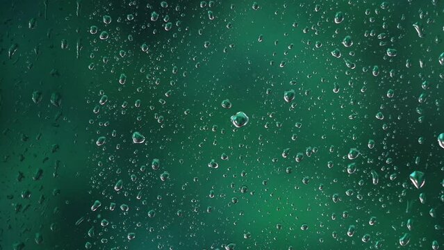 Raindrops on window with blurred green background. Motion graphic
