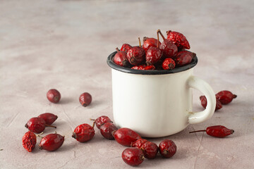 Dried rose hips in a mug on the table.