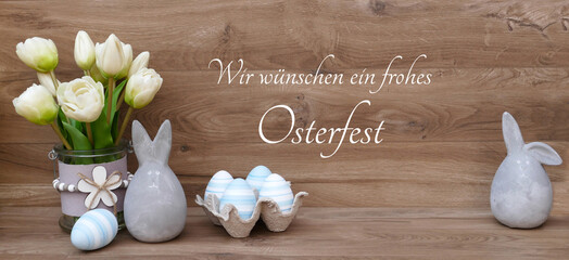 Osterkarte Frohe Ostern. Ein Strauß Tulpen, Osterhasen und Eier mit dem Text Wir wünschen ein frohes Osterfest.