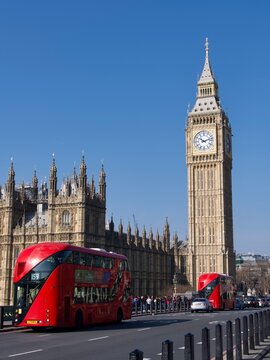 golden big ben clock  London England Parliament red buses on bridge blue sky 