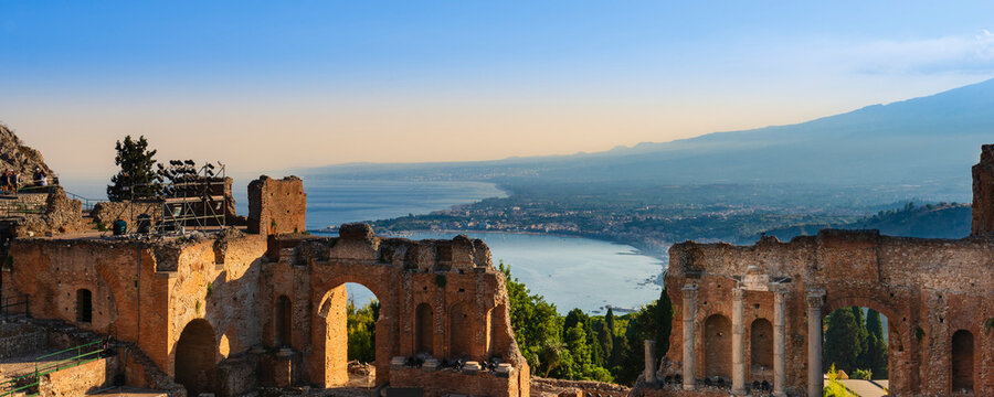 Ruins of a Greek theatre and view of the coastline at sunset in Taormina, Sicily, Italy; Taormina, Sicily, Italy