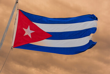 Cuban flag flying proudly against an overcast sky at twilight; Cayo Guillermo, Cuba