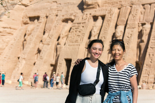 Mother and daughter tourists standing in front of the Temple of Hathor at Abu Simbel; Aswan, Nubia, Egypt