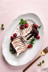 Pancake chocolate cake with fresh raspberries on a pink background.