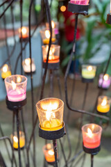 Closeup of burning candles in metal grid.