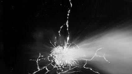 Close-up of gunshot through the glass, shattering against the black background