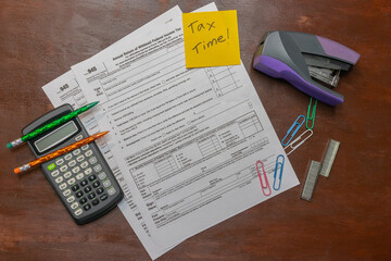 Flat lay of tax form 945 for federal taxes for self employment and freelance work with calculator...