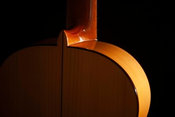 Classical Spanish flamenco guitar close up, dramatically lit isolated on black background with copy...