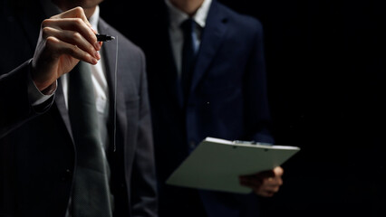 Businessmen in close-up discussing business in a dark office