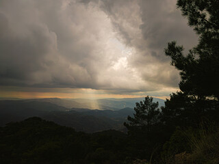 The sunbeam breaks through the clouds on the hills