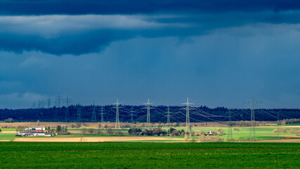 Naklejka premium Strommasten einer Überlandleitung und dunkler Wolkenhimmel