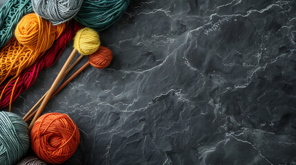 Colorful yarn balls and knitting needles on grey background with copy space