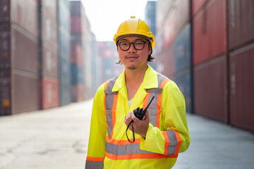 Asia logistic engineer man worker or foreman working with walkie talkie at container site	 - 763416626
