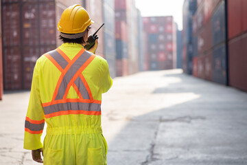 Asia logistic engineer man worker or foreman working with walkie talkie at container site	 - 763416646