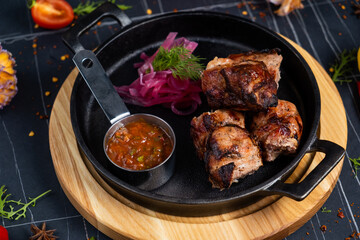 Chicken skewers with apples and vegetables on a black background