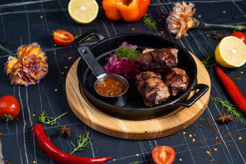 Chicken skewers with apples and vegetables on a black background