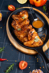 Baked chicken wings with sesame and sauce. Food background with copy space. Top view