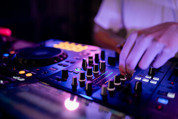 Close-up of DJ working using mixing table in a club
