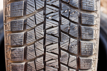 small rocks stuck in car tire tread, closeup.