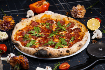 Traditional italian pizza with salami cheese, tomatoes and basil.