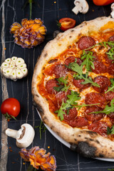 Traditional italian pizza with salami cheese, tomatoes and basil.