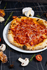 Traditional italian pizza pepperoni with salami and cheese on a dark slate, stone, metal or concrete background.Top view with copy space.