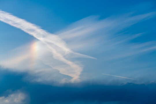 Sky with cirrus, stratus clouds and halo from the sun, rainbow
