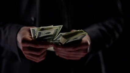 Businessman in close-up counting illegal money, the concept of crime