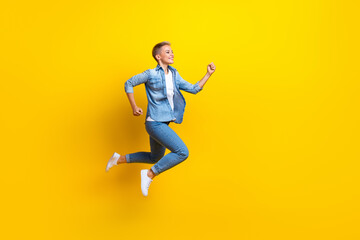 Fototapeta na wymiar Full length photo of lovely young lady running fast shopping wear trendy jeans garment isolated on yellow color background
