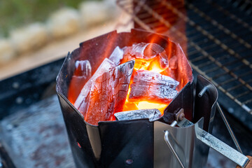 Barbecue grill  preparation with glowing and burning hot charcoal in the garden, close-up photo