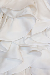 White satin folded material texture of a bridal gown