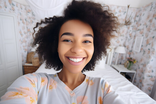 Young African American woman in a pink blouse smiling and taking a selfie 