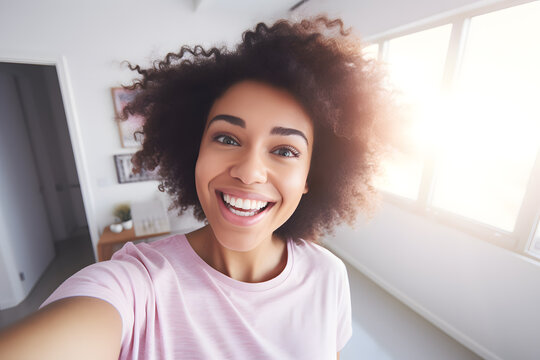 Young African American woman in a pink blouse smiling and taking a selfie 