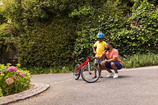 African American father teaches his son to ride a bike