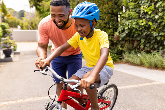 African American father teaches his son to ride a bike