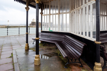 New Brighton sea front with ornate Victorian shelter with wooden seating