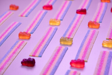 pink background of various jelly sweets, bears, donuts, candies, on pink background close-up top view concept birthday party or celebration 