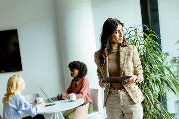 Young Professional Woman Holding a Tablet Amidst Colleagues in Contemporary Office - 763446453