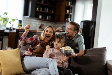 Family Movie Night: Engrossed in Thrilling Scenes at Home - 763446899