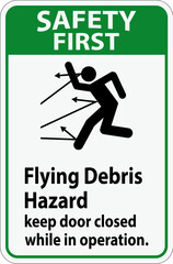 Safety First sign indicating the risk of flying debris, advising to keep the door closed.