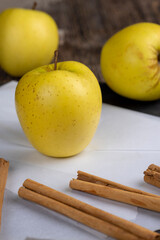 yellow ripe apple with cinnamon on the table